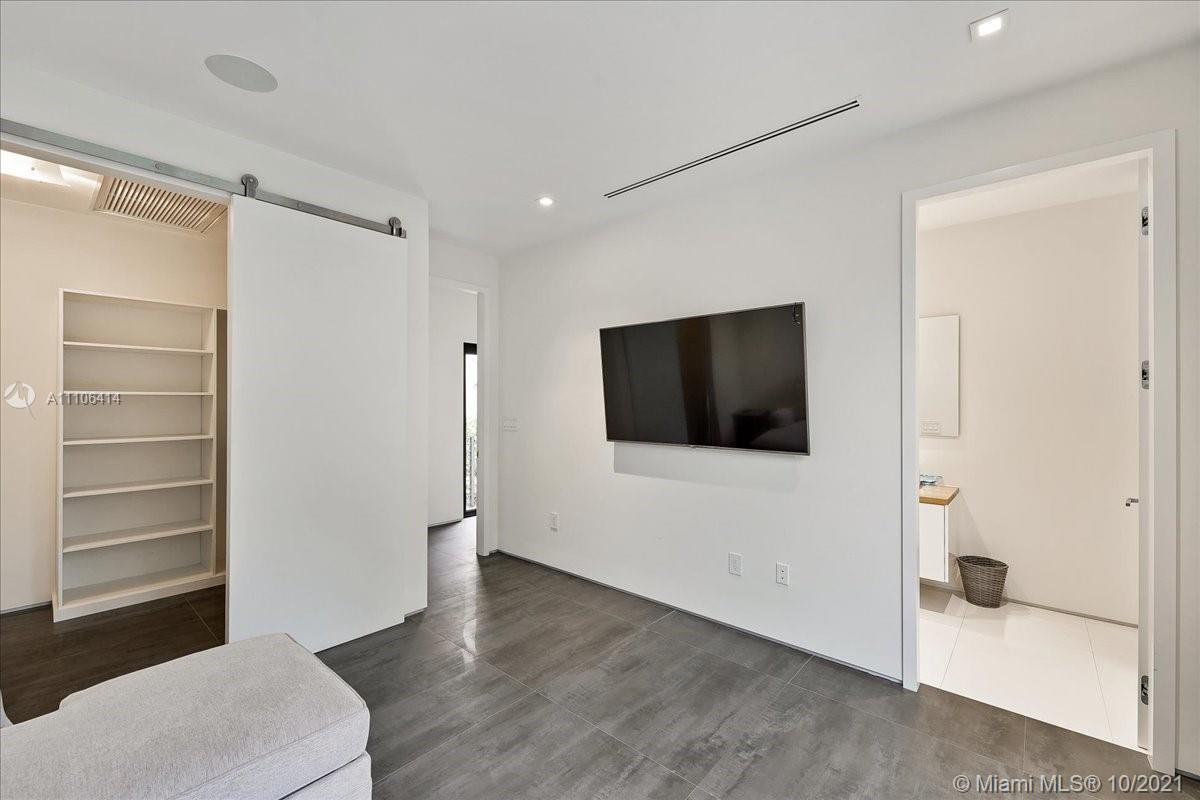 2125 North Bay Road Miami Beach, FL 33140 - Photo 34 of 71 a living room with a flat screen tv a vanity and a toilet