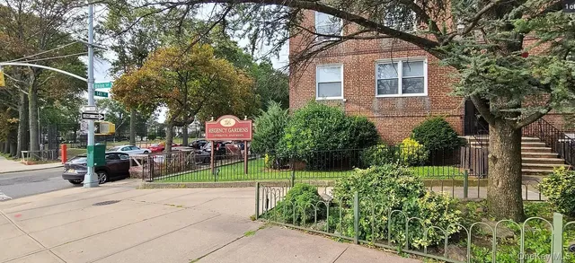 a view of a white house with a yard and potted plants