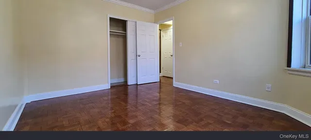 a view of an empty room with closet and a window