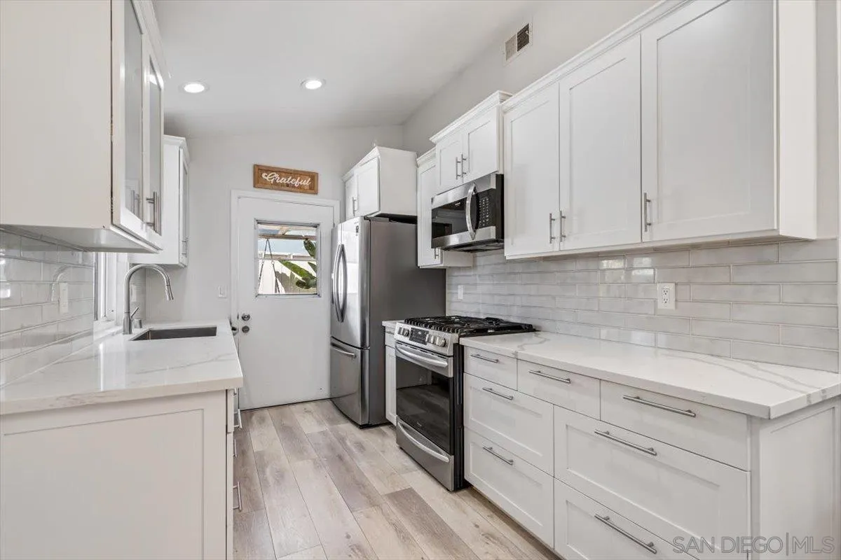 2019 Bridgeport Chula Vista, CA 91913 - Photo 7 of 32 a kitchen with stainless steel appliances granite countertop white cabinets a sink a stove a refrigerator and white cabinets