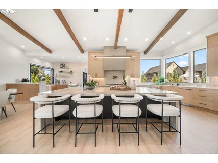 a dining hall with stainless steel appliances kitchen island a table and chairs