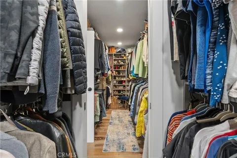 a view of walk in closet with clothes and shoes