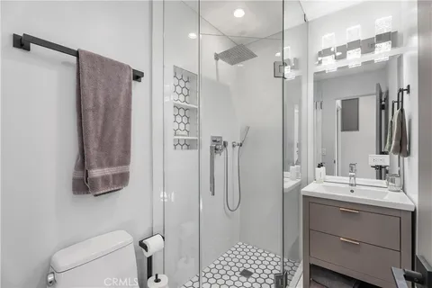 a bathroom with a shower a sink a toilet and mirror