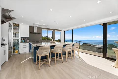 a dining room with furniture a rug and kitchen view