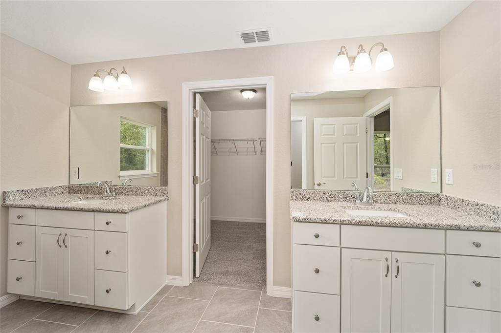 17600 Southwest 113th Place Dunnellon, FL 34432 - Photo 19 of 33 a bathroom with a granite countertop sink two mirror and a