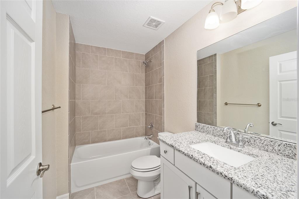 17600 Southwest 113th Place Dunnellon, FL 34432 - Photo 23 of 33 a bathroom with a granite countertop sink a toilet a mirror and bathtub