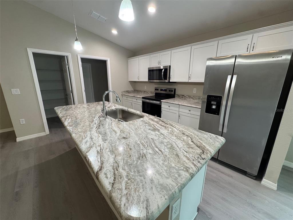 17600 Southwest 113th Place Dunnellon, FL 34432 - Photo 5 of 33 a kitchen with granite countertop a refrigerator a sink a stove a microwave and island