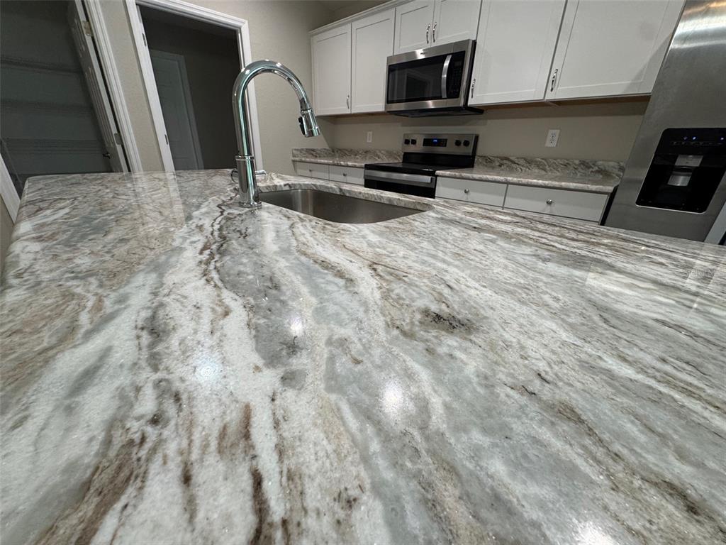 17600 Southwest 113th Place Dunnellon, FL 34432 - Photo 6 of 33 a kitchen with stainless steel appliances a refrigerator a stove a sink cabinets and a dining table