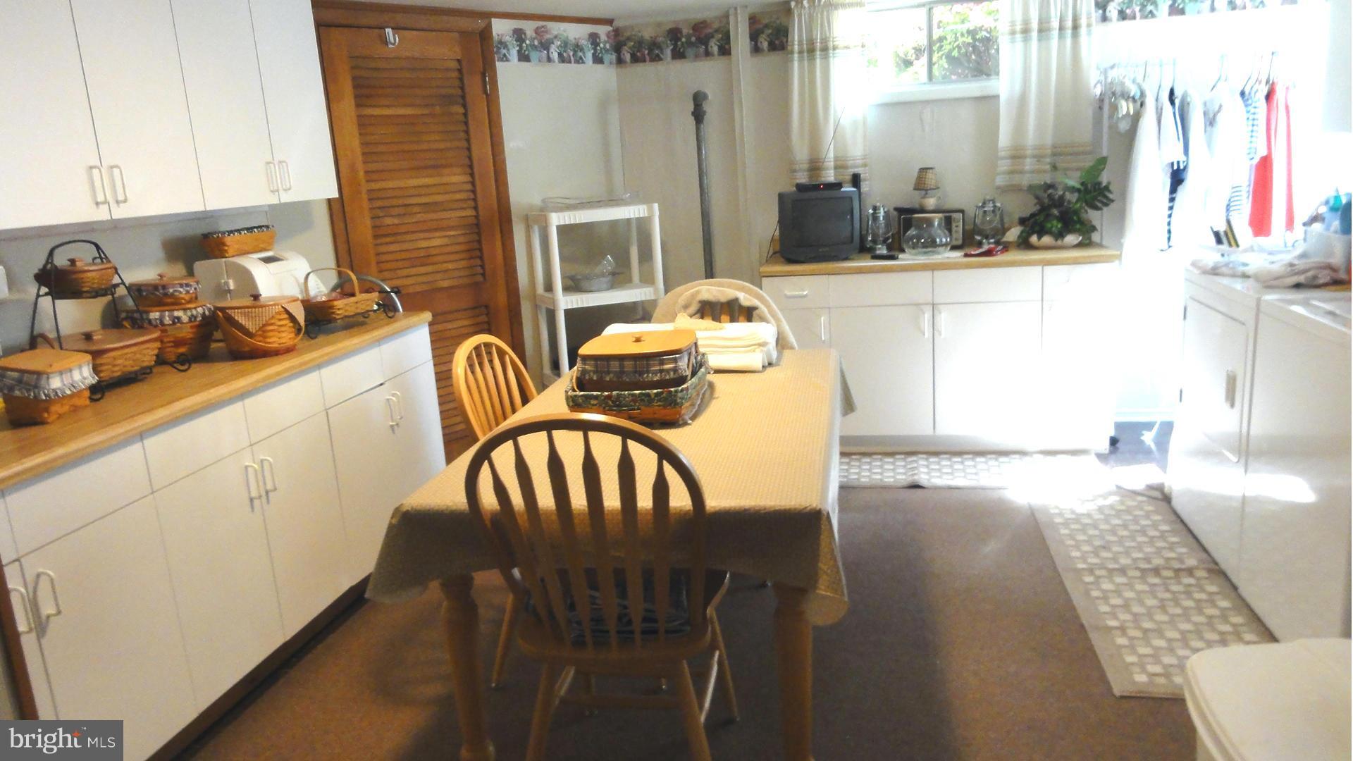 3726 Collier Road Randallstown, MD 21133 - Photo 16 of 20 a kitchen with stainless steel appliances wooden floor dining table and chairs