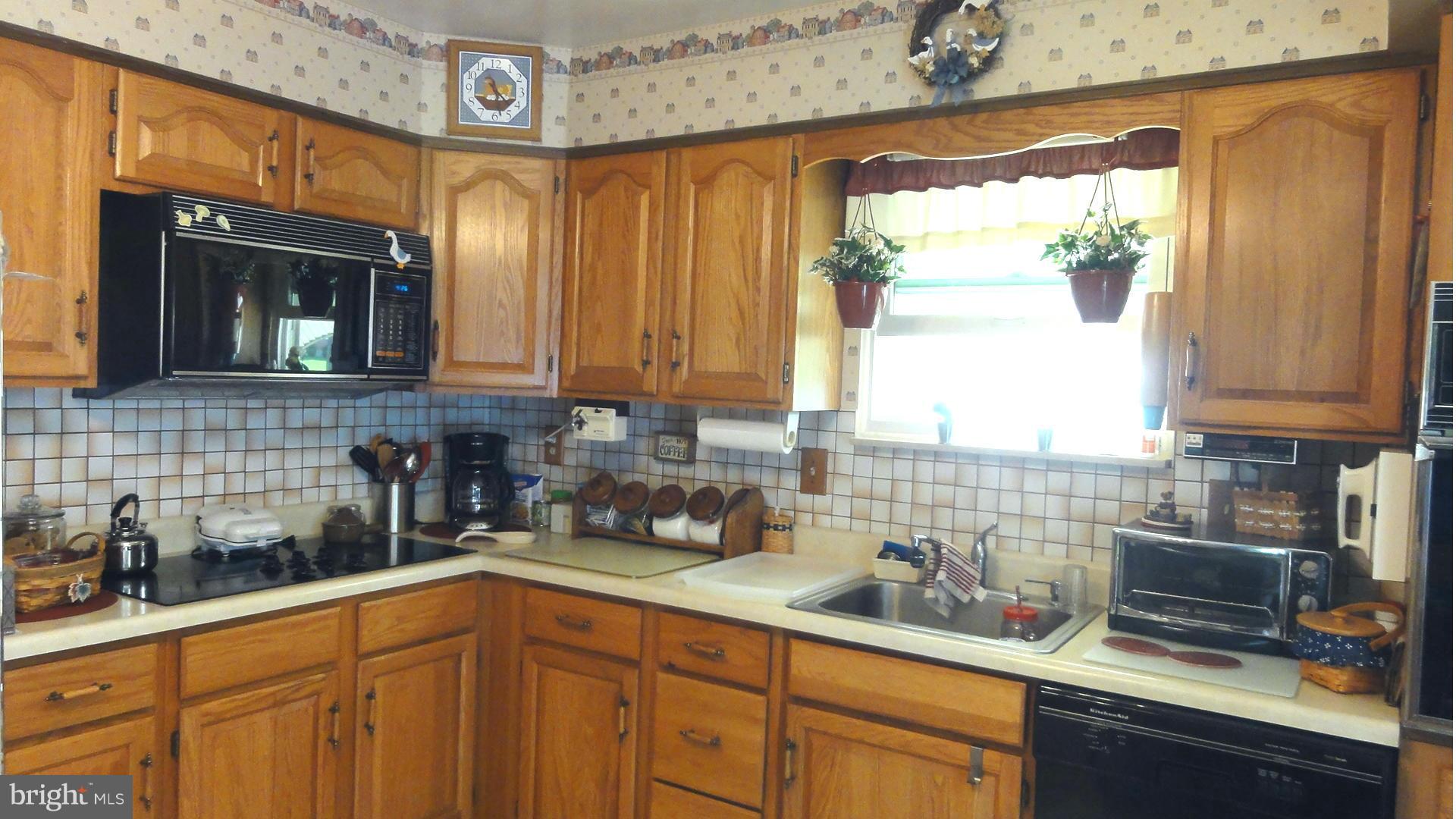3726 Collier Road Randallstown, MD 21133 - Photo 6 of 20 a kitchen with stainless steel appliances a sink a window and cabinets