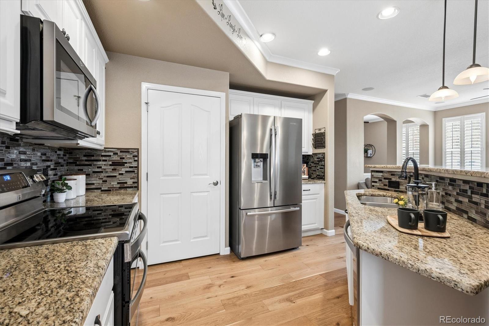 485 Elmhurst Way, Unit C Highlands Ranch, CO 80129 - Photo 18 of 42 a kitchen with granite countertop a refrigerator stove and sink