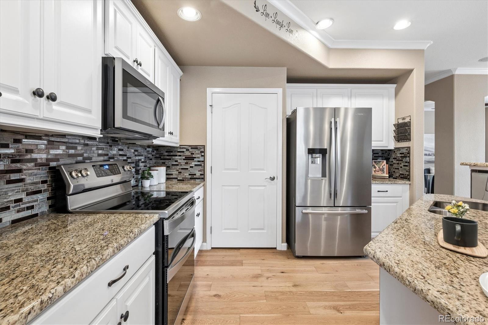 485 Elmhurst Way, Unit C Highlands Ranch, CO 80129 - Photo 19 of 42 a kitchen with stainless steel appliances granite countertop a refrigerator a stove and a sink