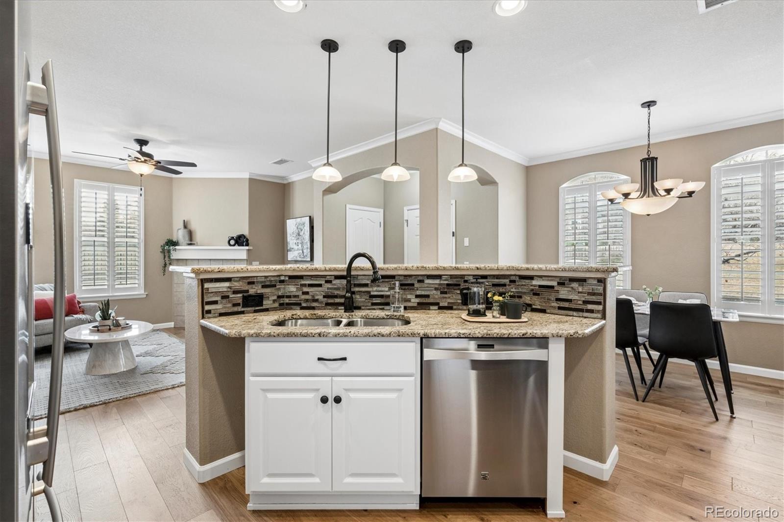 485 Elmhurst Way, Unit C Highlands Ranch, CO 80129 - Photo 23 of 42 a kitchen with a stove a refrigerator a dining table and chairs