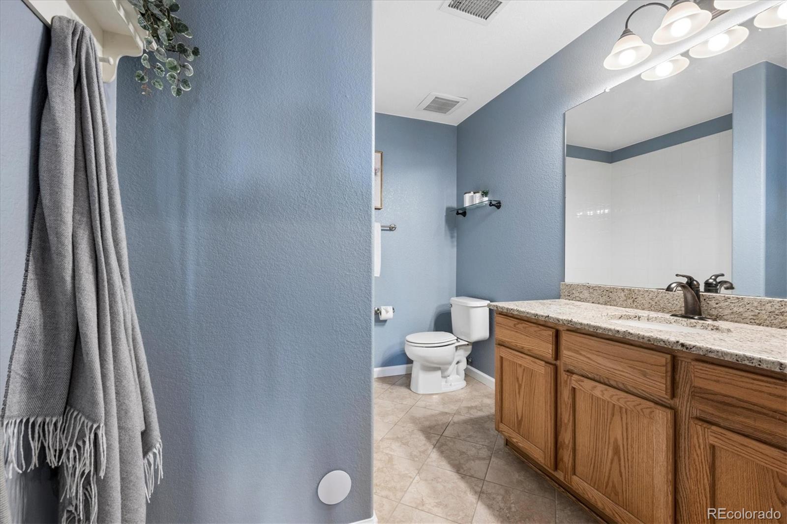 485 Elmhurst Way, Unit C Highlands Ranch, CO 80129 - Photo 26 of 42 a bathroom with a granite countertop sink toilet and shower