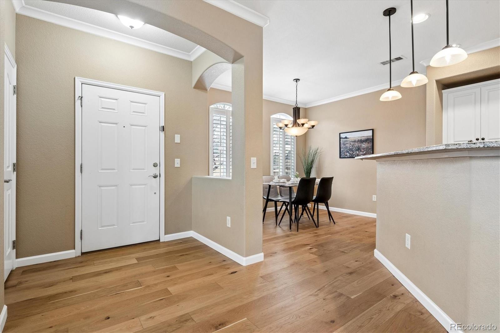 485 Elmhurst Way, Unit C Highlands Ranch, CO 80129 - Photo 5 of 42 a view of a room with wooden floor and chairs