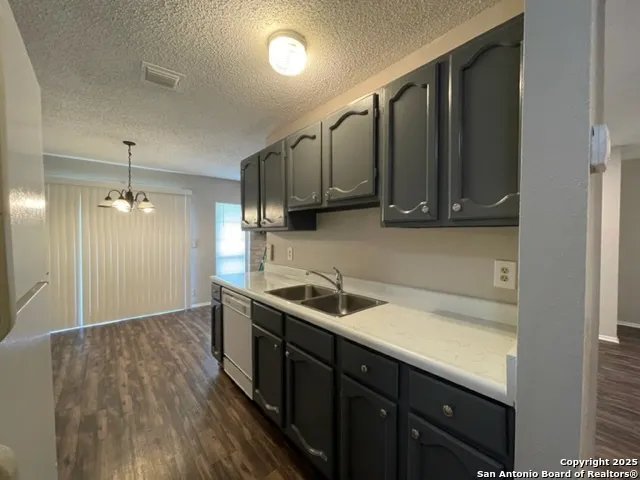 a kitchen with stainless steel appliances granite countertop a sink a stove and a refrigerator