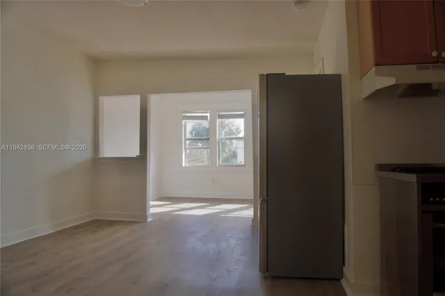 a view of an empty room with closet and a window