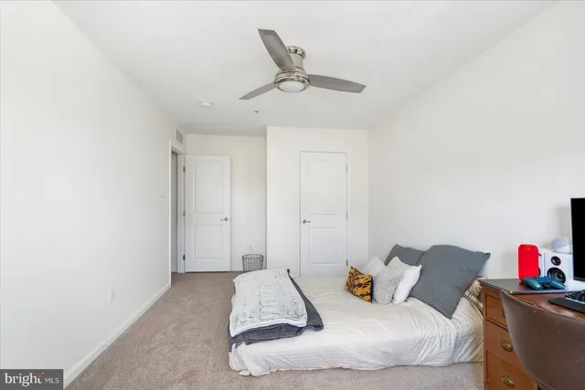 a living room with furniture and a ceiling fan