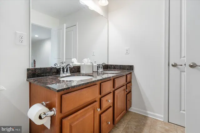 a bathroom with a granite countertop sink and a mirror