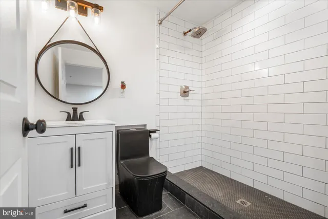 a bathroom with a toilet a sink and mirror