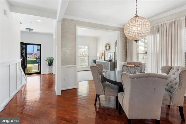 a dining room with furniture a chandelier and wooden floor
