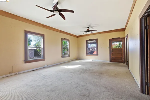 a view of an empty room with windows and cabinet