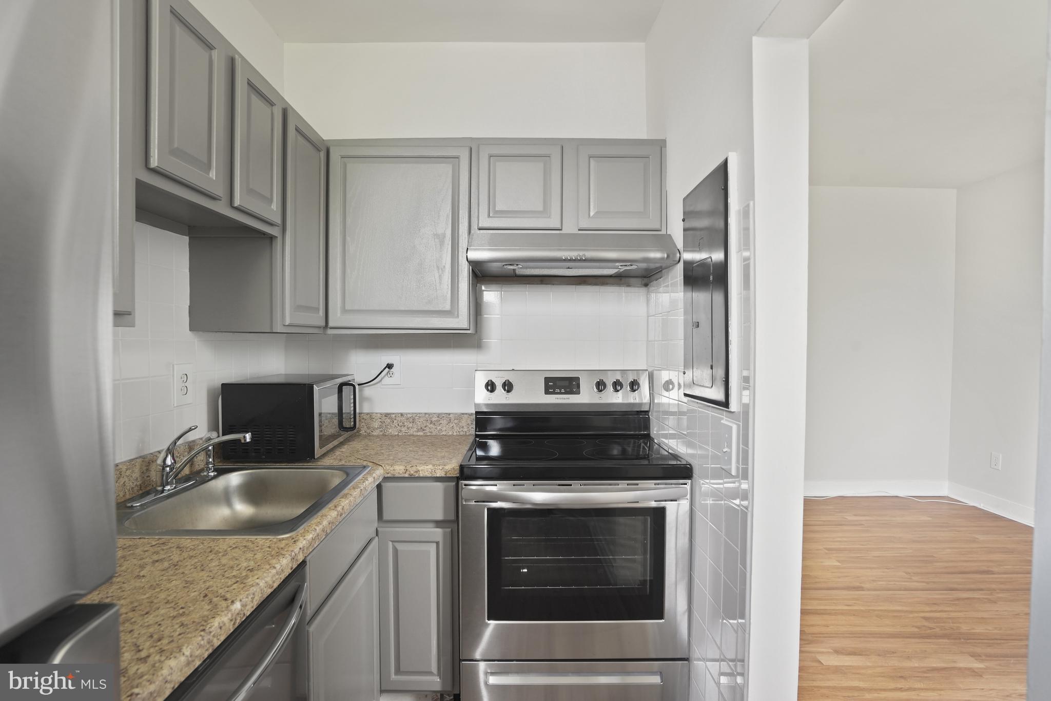 7 18th Street Southeast, Unit 208 Washington, DC 20003 - Photo 9 of 21 a kitchen with granite countertop stainless steel appliances sink stove and cabinets