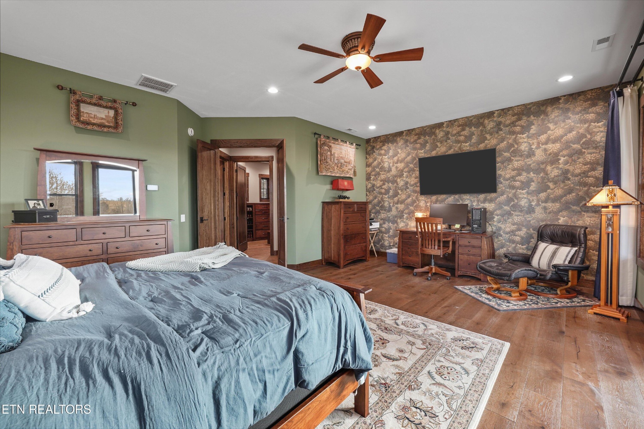 1150 Hillendale Road Crossville, TN 38572 - Photo 26 of 42 a spacious bedroom with a bed a couch and a flat tv screen on dresser
