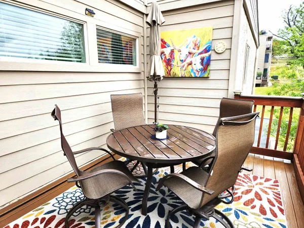 a view of a dining room with furniture a rug and wooden floor