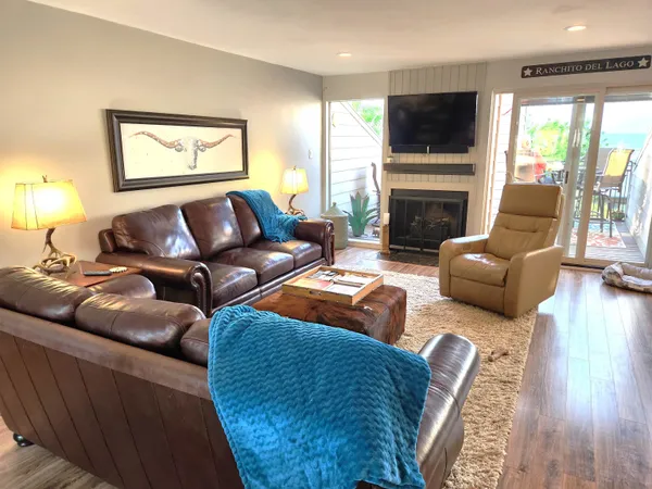 a living room with furniture a flat screen tv and a fireplace