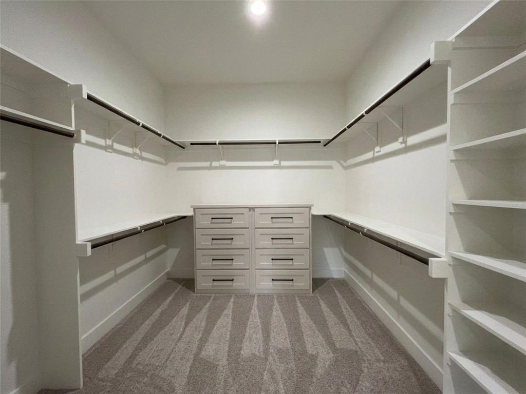 121 Cartwright Park Road Weatherford, TX 76087 - Photo 9 of 17 Spacious walk-in closet featuring built-in shelving, hanging rods, and a central dresser island with multiple drawers