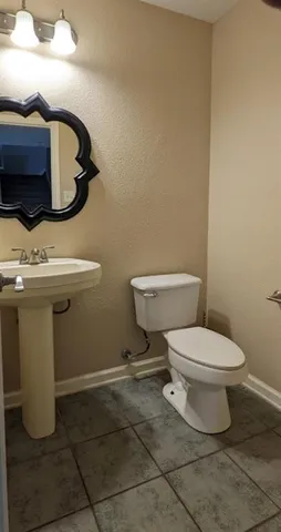 a white toilet sitting next to a bathroom sink