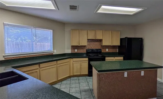 a kitchen with stainless steel appliances granite countertop a stove a sink dishwasher and a refrigerator