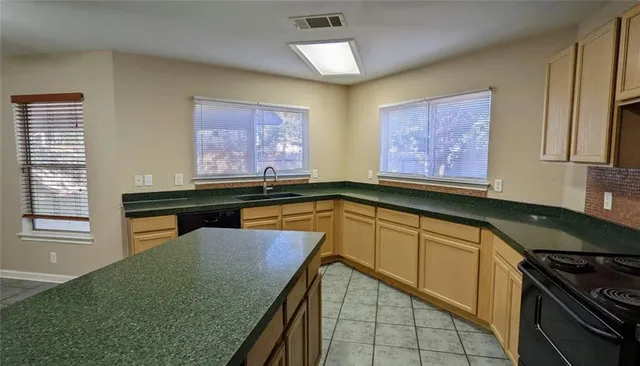 a kitchen with granite countertop sink stove and cabinets