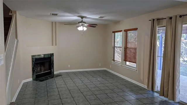 a view of an empty room with a fireplace and a window