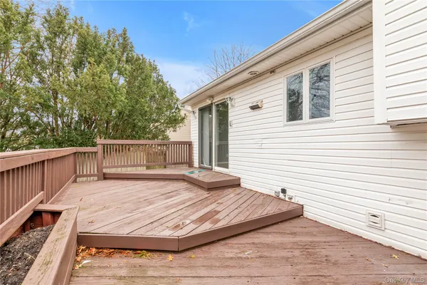a view of a backyard with wooden floor and fence