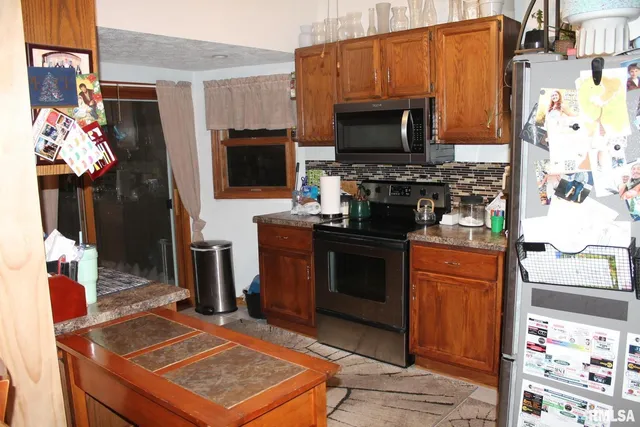 a kitchen with stainless steel appliances granite countertop a sink a stove and a refrigerator