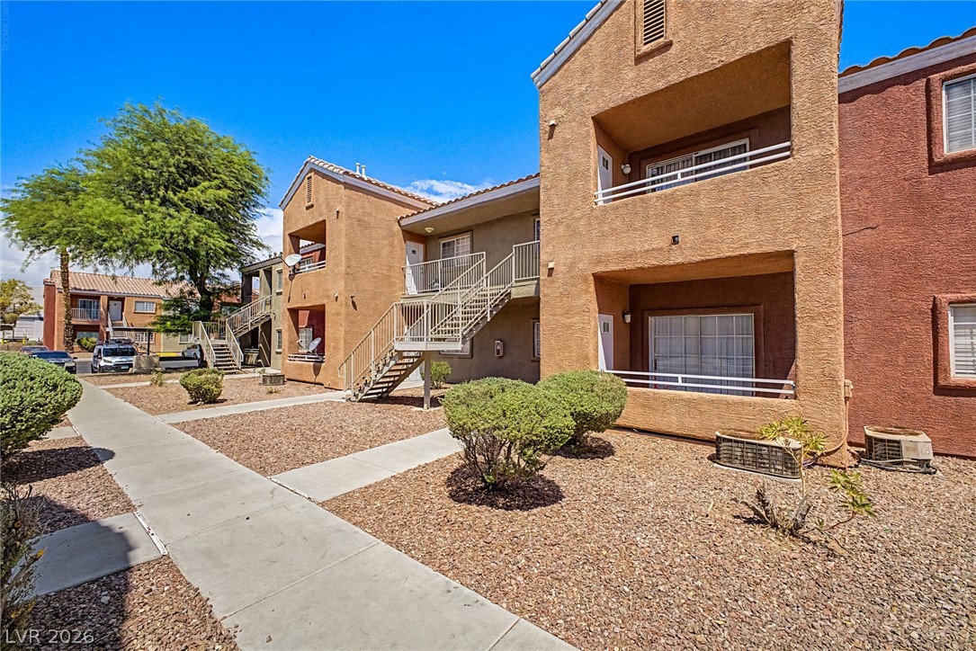 4730 East Craig Road, Unit 2096 Las Vegas, NV 89115 - Photo 3 of 35 Well-maintained grounds frame this stucco multi-family building with convenient outdoor stair access to upper units.