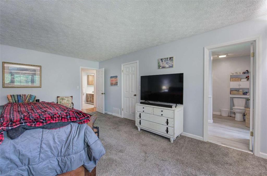 567 Fred Kelly Road Northeast Rome, GA 30161 - Photo 24 of 59 a bedroom with a bed and a flat screen tv