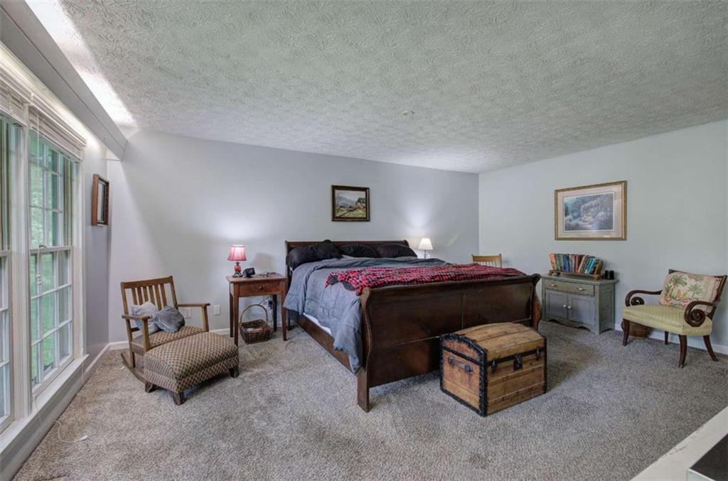 567 Fred Kelly Road Northeast Rome, GA 30161 - Photo 28 of 59 a spacious bedroom with a bed and a couch