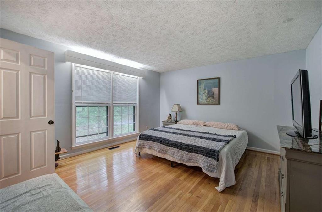 567 Fred Kelly Road Northeast Rome, GA 30161 - Photo 30 of 59 a spacious bedroom with a bed and a flat tv screen on the dresser