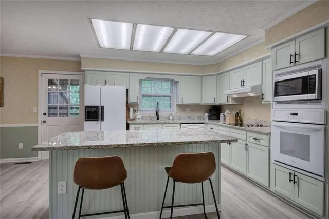 a open dining room with stainless steel appliances kitchen island granite countertop furniture and wooden floor