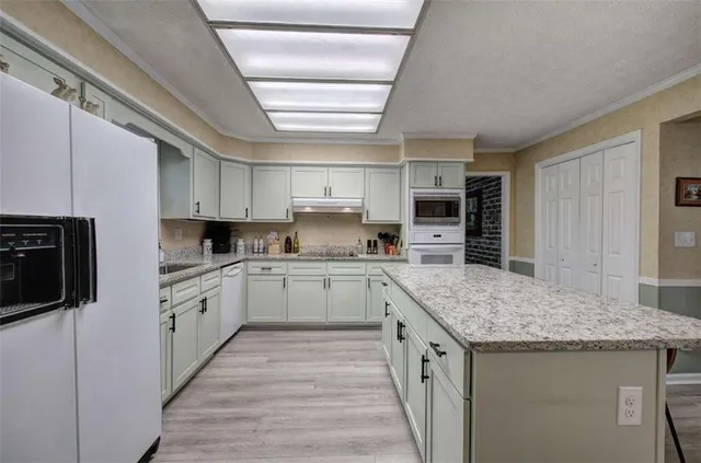 a kitchen with stainless steel appliances granite countertop a refrigerator and a stove top oven