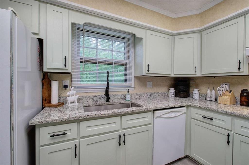 567 Fred Kelly Road Northeast Rome, GA 30161 - Photo 38 of 59 a kitchen with granite countertop white cabinets and white appliances