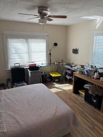 a bedroom with a bed a chandelier and a window