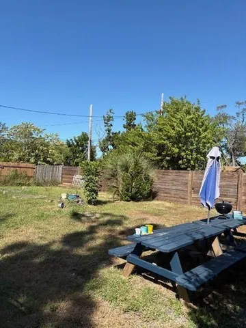 a front view of a house with a yard and a large tree