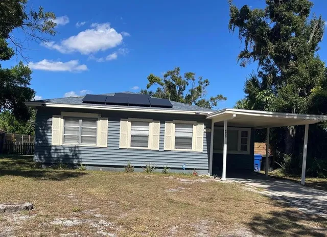a view of a house with backyard and sitting area