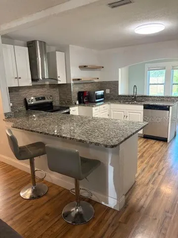a kitchen with kitchen island granite countertop wooden cabinets and a granite counter tops