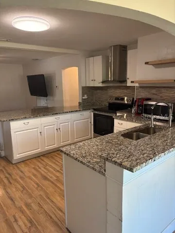 a kitchen with stainless steel appliances granite countertop a sink stove and cabinets
