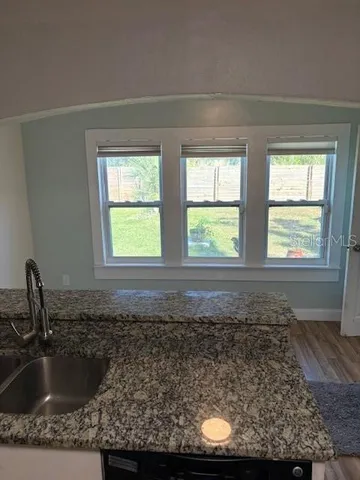 a bathroom with a granite countertop sink and window